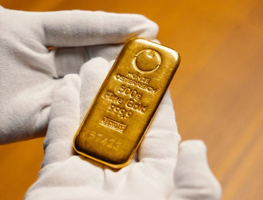 Hände halten 500g Goldbarren, „500g Feingold 999,9“.