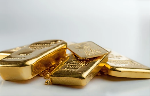 Ein Stapel von Goldbarren und Goldnuggets auf weißem Hintergrund, der Gold als Bestandteil der Altersvorsorge symbolisiert.