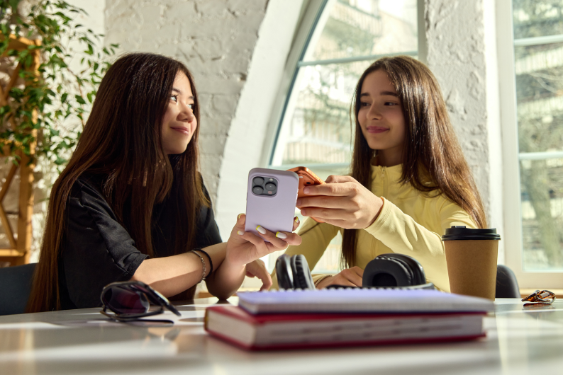 Jugendliche nutzen Smartphones und lernen finanzielle Kompetenzen am Weltjugendkompetenztag.