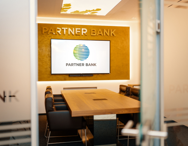 Modern office with a screen, meeting table, and chairs, reflecting women’s financial freedom and Partner Bank values.