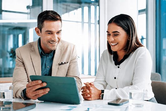 Mann und Frau besprechen Anlageinformationen auf einem Tablet sowie mögliche Risiken und langfristige Investitionsentscheidungen